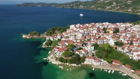 Aerial drone video of picturesque main town of Skiathos island featuring small landmark peninsula of Bourtzi, Sporades, Greece