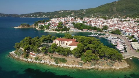 Aerial drone video of picturesque main town of Skiathos island featuring small landmark peninsula of Bourtzi, Sporades, Greece