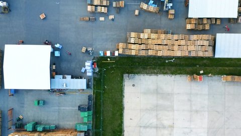 Outside storage (storage yard) of wooden pallets in logistics park with warehouse. Aerial top down view
