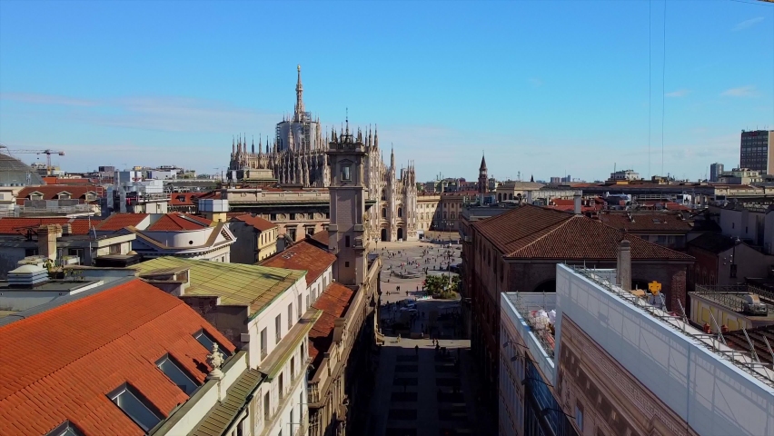 Aerial view of Piazza Duomo in front of the gothic cathedral in the center. Drone view of the gallery and rooftops during the day. Flight over the city. People in the city. Milan. Italy 2020 Royalty-Free Stock Footage #1061476738