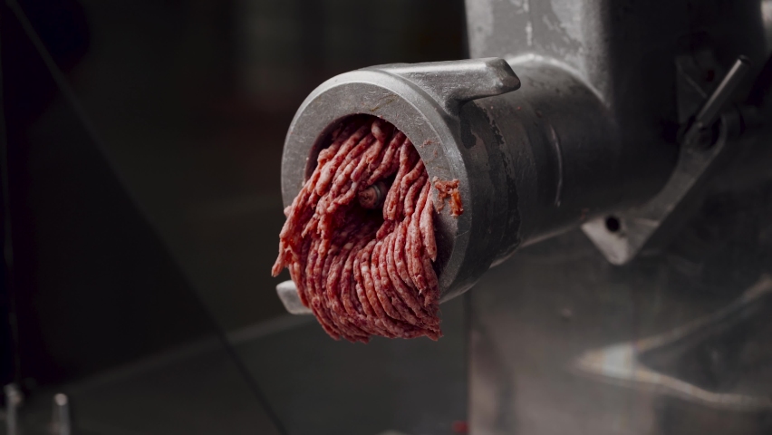 Industrial processing lard or beef meat in minced meat on a huge meat grinder at a meat factory closeup | Shutterstock HD Video #1061478487