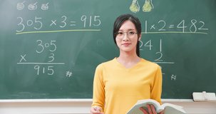 asian elementary school female teacher teach math online through webcam in classroom