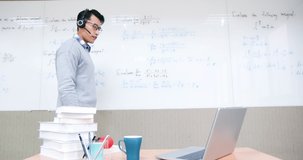 asian male professor teach calculus online through laptop in classroom