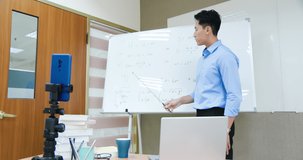 asian senior high school male teacher teach physical online through mobile phone in classroom