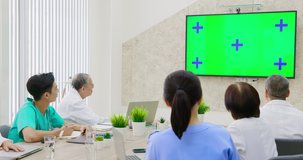 Team of asian doctors having a meeting in conference room with green screen TV - Healthcare and science concept