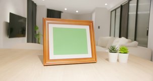 close up of photo frame with green copy space on table in living room at home