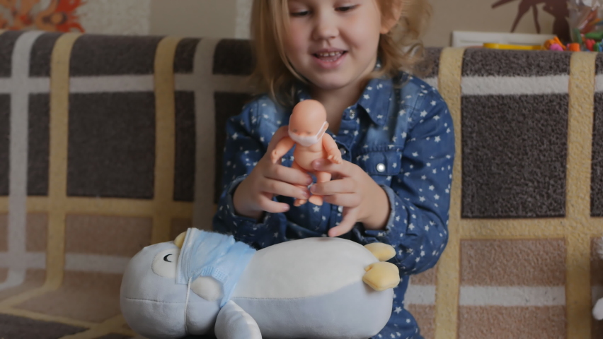 little girl in her room plays with toys. Her toys have safety masks on their faces. To protect against diseases and viruses. The concept of caring for loved ones. 4k