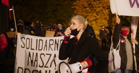 Szczecin / Poland - 10 23 2020: woman raising her voice with a crowd of protestors at Szczecin Poland 