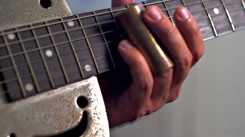 Man Playing Old Metallic Resonator Guitar with Slide Close Up