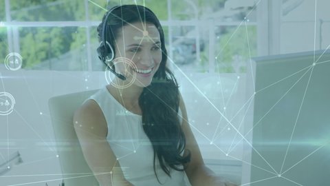 Animation of a web of connection with graphs floating over Caucasian female call centre worker talking on the phone, wearing headphones, smiling to the camera. Digital composite video