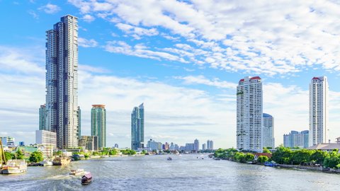 Bangkok city center financial business district, waterfront cityscape and Chao Phraya River during sunny day; zoom out - Time Lapse