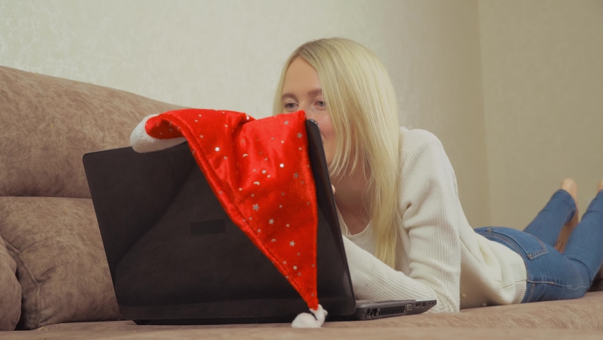 A woman is holding a gift and typing on a laptop. Buying on Internet.