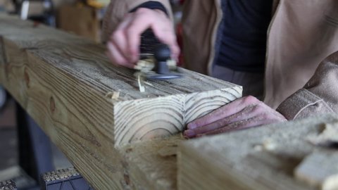 An individual works on a woodworking project from the perspective of his hands.