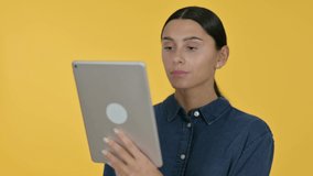 Video Chat on Tablet by Young Latin Woman, Yellow Background 
