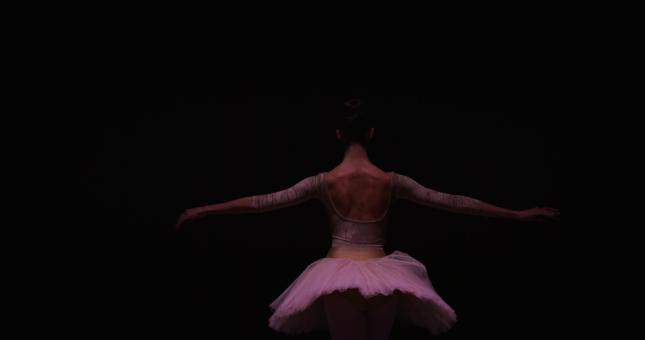 Cinematic Back View of Young Classical Ballet Female Dancer Standing on Classic Theatre Stage with Spotlights for the Curtain Call. Graceful Performer Accepting the Audiences' Applause for her Talent Royalty-Free Stock Footage #1061502958