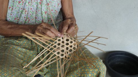4K Old woman hands weaving  bamboo wooden basket. Handmade and rural people lifestyle concept.