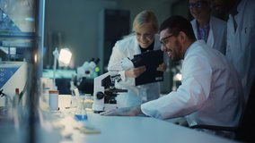 Surprized Male Reseach Scientist Makes an Important Discovery While Researching Samples Under the Microscope. Happy Colleagues Give High Five and Share Success with Fellow Bioengineers. - Powered by Shutterstock - Get 15% off with code: PIKWIZARD15