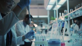 Close Up of a Female Research Scientist Using Micropipette to Mix Liquids in a Test Tube in a Modern Laboratory. Scientists are Conducting Research with the Help of Microscope and Tablet Computer. - Powered by Shutterstock - Get 15% off with code: PIKWIZARD15