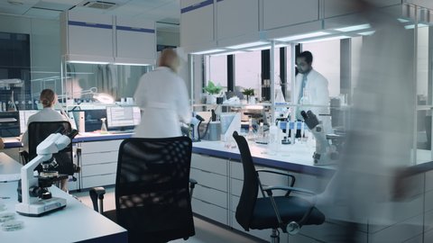 Timelapse Footage of a Team of Medical Research Scientists Conduct Experiments with Help of Microscope, Test Tubes and Writing Down Analysis Results on a Computer. Modern Applied Science Laboratory.