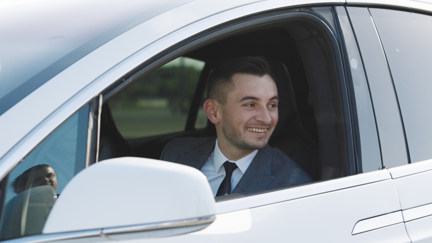 Car Salesman Finishing Up Dealing Car. Young Happy Man Receiving Car Keys to Her New Automobile. Dealer giving key to new owner in auto show or salon. Royalty-Free Stock Footage #1061506639