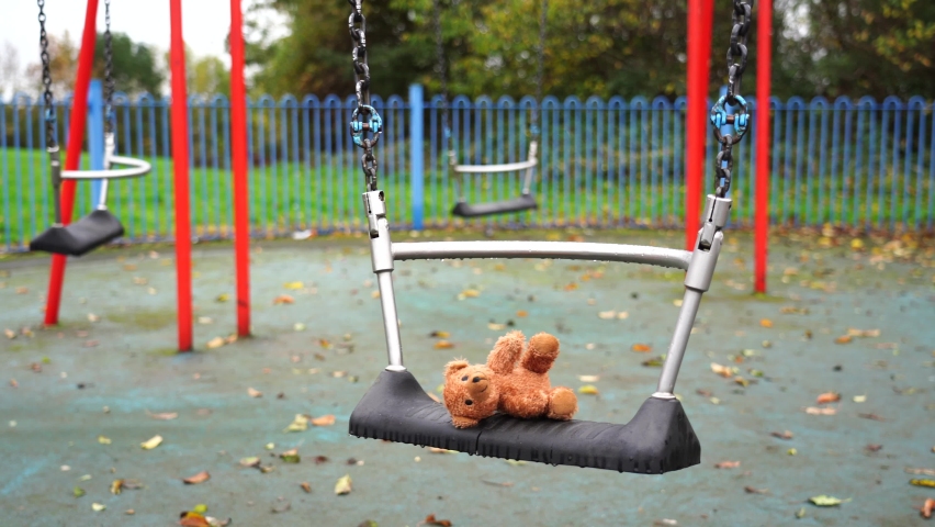 Lost Teddy bear lying on swing with rain drops at playground in gloomy day, Lonely or sad brown bear abandoned lied down alone in the park,Loneliness concept, International missing children's day Royalty-Free Stock Footage #1061510029