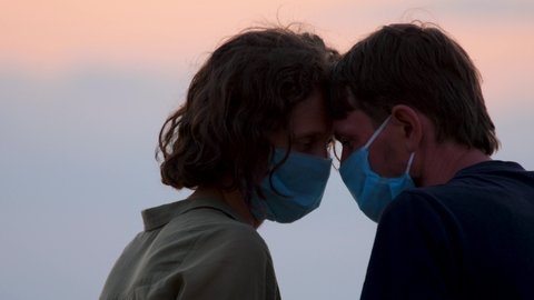 Couple in protective masks. Tender moment family support, forgive and understanding during Covid-19, Coronavirus pandemic. Young couple in mask support each other. Man and woman in medical face mask