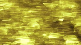 Defocused video of golden bokeh of reflected sun rays on a surface of the water. Abstract yellow video background.