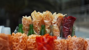 4k Video of Mexican fried snacks, potato chips, and empty soda bottles with a blurry background
