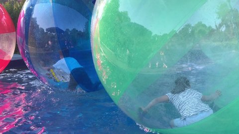 Sochi, Russia - June 15, 2019: Children play in the pool inside large balls. orb. Zorbing is a type of activity on water for fun and joy.