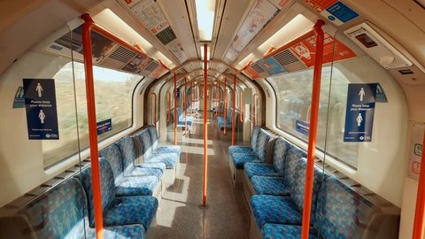 LONDON, circa 2020 - The impact of COVID-19 / CORONAVIRUS on public transport - POV of an empty Central Line carriage of London Underground with social distancing messages spread throughout