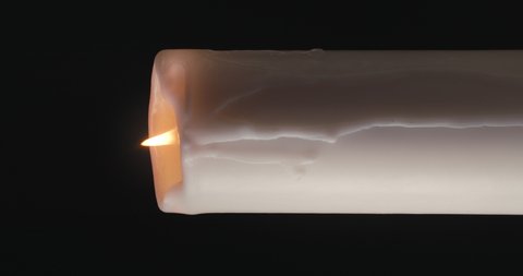 white candle on black background. vertical video