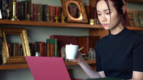 Portrait of a young asian woman using a laptop computer.