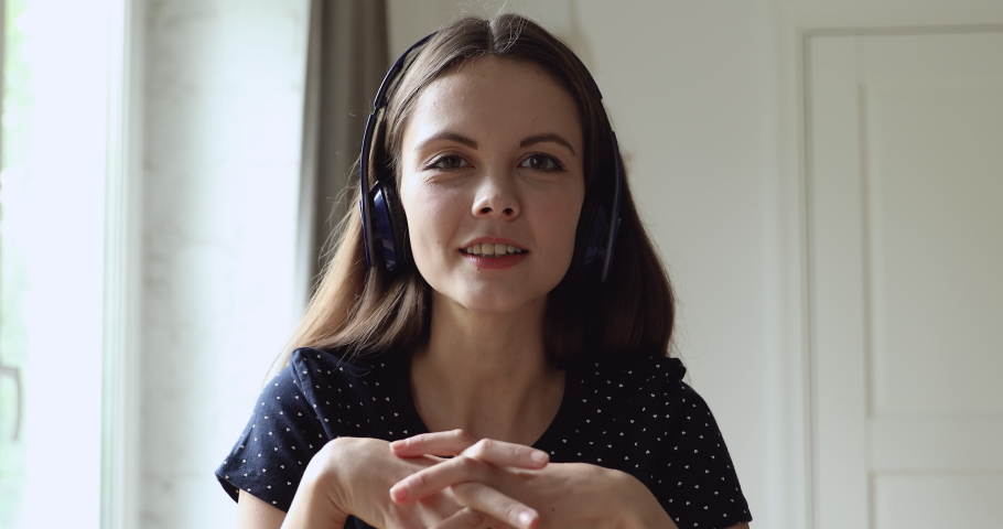 Web camera view young happy european woman in wireless headphones holding video call, talking with friends, passing job interview online, communicating with clients, giving professional consultation. Royalty-Free Stock Footage #1061549977