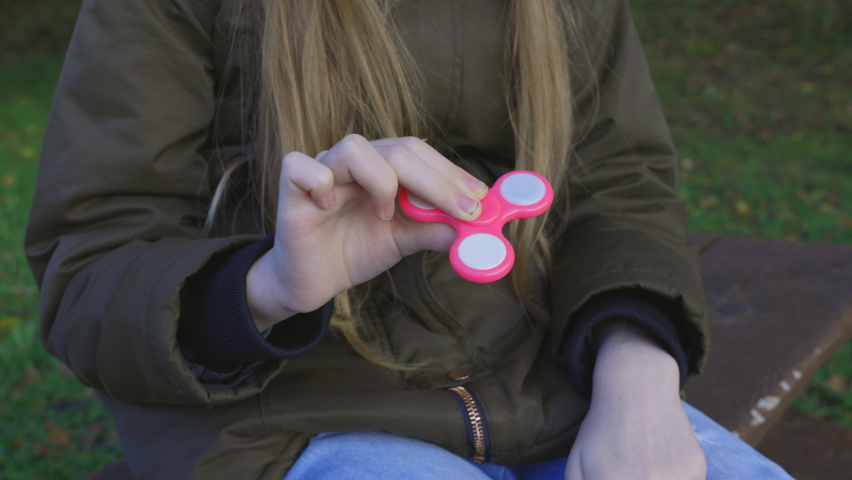 Little girl holding and playing with spinner