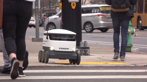 PITTSBURGH, PA - JANUARY 11: Starship delivery robot crossing street with pedestrians Pittsburgh, Pennsylvania on January 11, 2020.