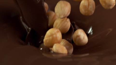Super slow motion of falling hazelnuts into dark hot chocolate. Filmed with cinema high speed camera, 1000fps.