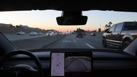 LOS ANGELES - OCT 30: A Tesla Model 3 performs automatic lane changes on Interstate 405 in Los Angeles on Oct 30, 2020. Tesla's Autopilot is updated over the air, increasing autonomy.