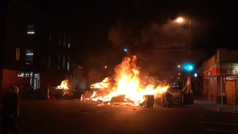 Minneapolis, Minnesota - 5/30/20: "George Floyd, Say His Name!" being chanted in front of a giant fire and street blockade set up in a scene that looks like civil war. Antifa and anarchist take over.