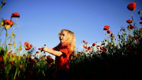 Happy baby child playing and jumping in poppy flower field at summer day. Childcare and childhood. Valentines day kids concept. Slow motion