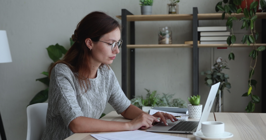 Stressed young businesswoman taking off glasses, feeling tired due to computer overwork, massaging nose bridge, exhausted female entrepreneur workaholic suffering from blurry vision at home office. Royalty-Free Stock Footage #1061572711