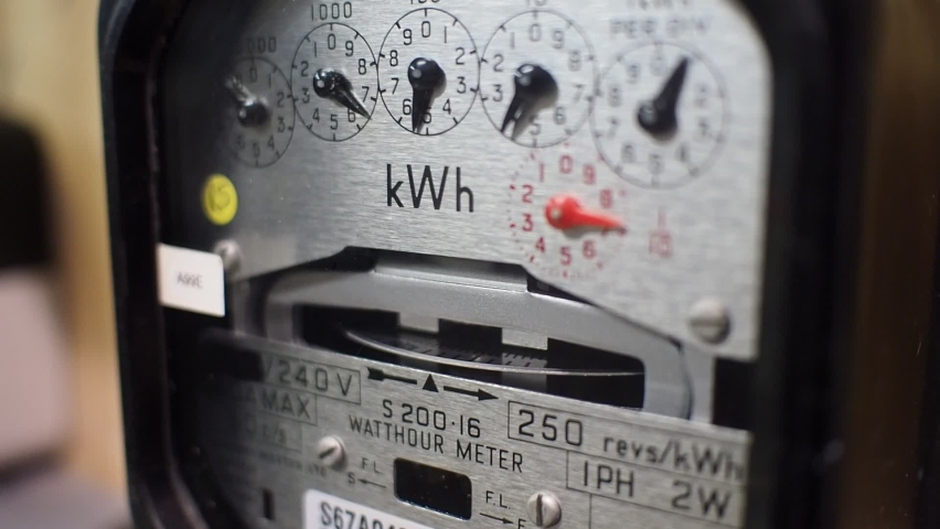 Close-up of a domestic electric meter and dial turning. Focus on Kwh symbol. Concept for energy, utility bills, price increase, meter reading and cost of living. Royalty-Free Stock Footage #1061573047