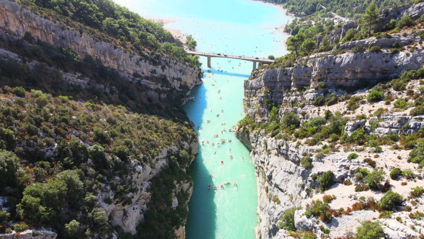 Narrow gorge or canyon full of kayaks, boats, paddlers and swimmers, aerial view