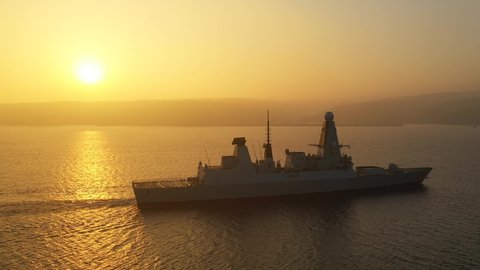 ISTANBUL - CIRCA 2020: Warship underway against the sun in mist. Royal Navy destroyer HMS Dragon sailed through Dardanelles and Bosporus bound for Black Sea port of Odesa, home of Ukrainian Navy
