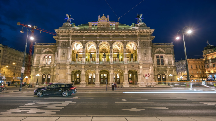 Beautiful view of Wiener Staatsoper (Vienna State Opera) aerial day to night transition timelapse in Vienna, Austria. Illuminated historic buildings and traffic on streets