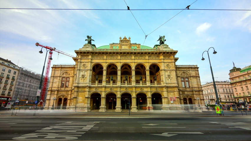 Beautiful view of Wiener Staatsoper (Vienna State Opera) aerial day to night transition timelapse in Vienna, Austria. Illuminated historic buildings and traffic on streets