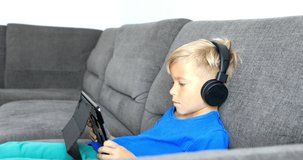 Little boy playing on tablet. The child spends his free time with modern technology. Stabilized video.
