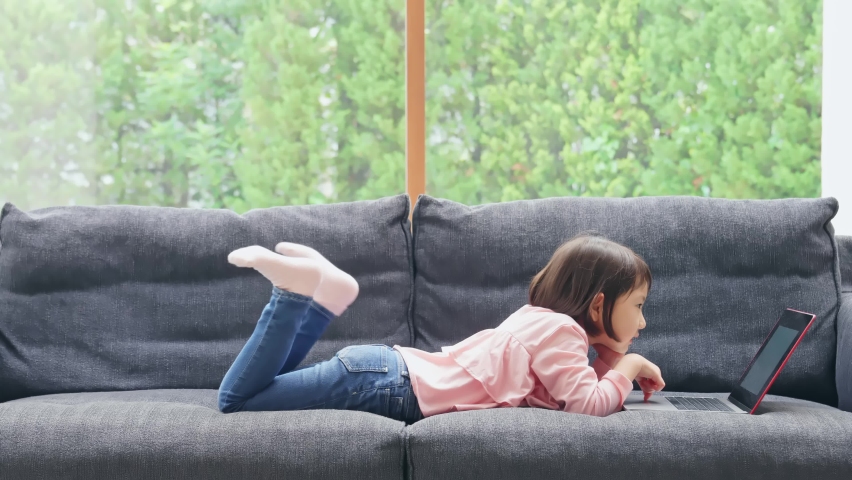 Little girl using a laptop PC.