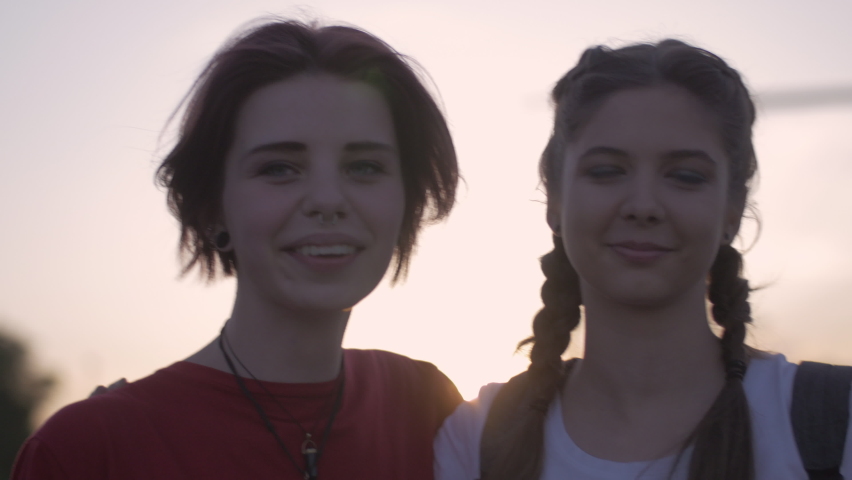 Two close friends saying goodbye and hugging each other at sunset. Smiling happy hipster girls having a farewell after spending the day together in the city. Royalty-Free Stock Footage #1061588299