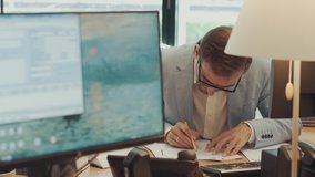 Serious young businessman checking corporate paperwork correspondence sitting at home office desk. Male entrepreneur reading documents, analyzing financial papers, preparing audit report at workplace. - Powered by Shutterstock - Get 15% off with code: PIKWIZARD15