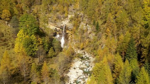 Waterfall and river in the mountains during autumn - aerial shot
